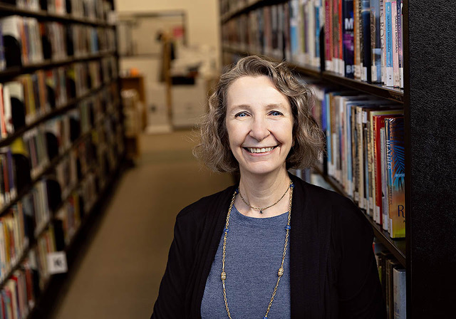 Portrait of Julie, a college essay coach, smiling in a professional yet approachable setting.